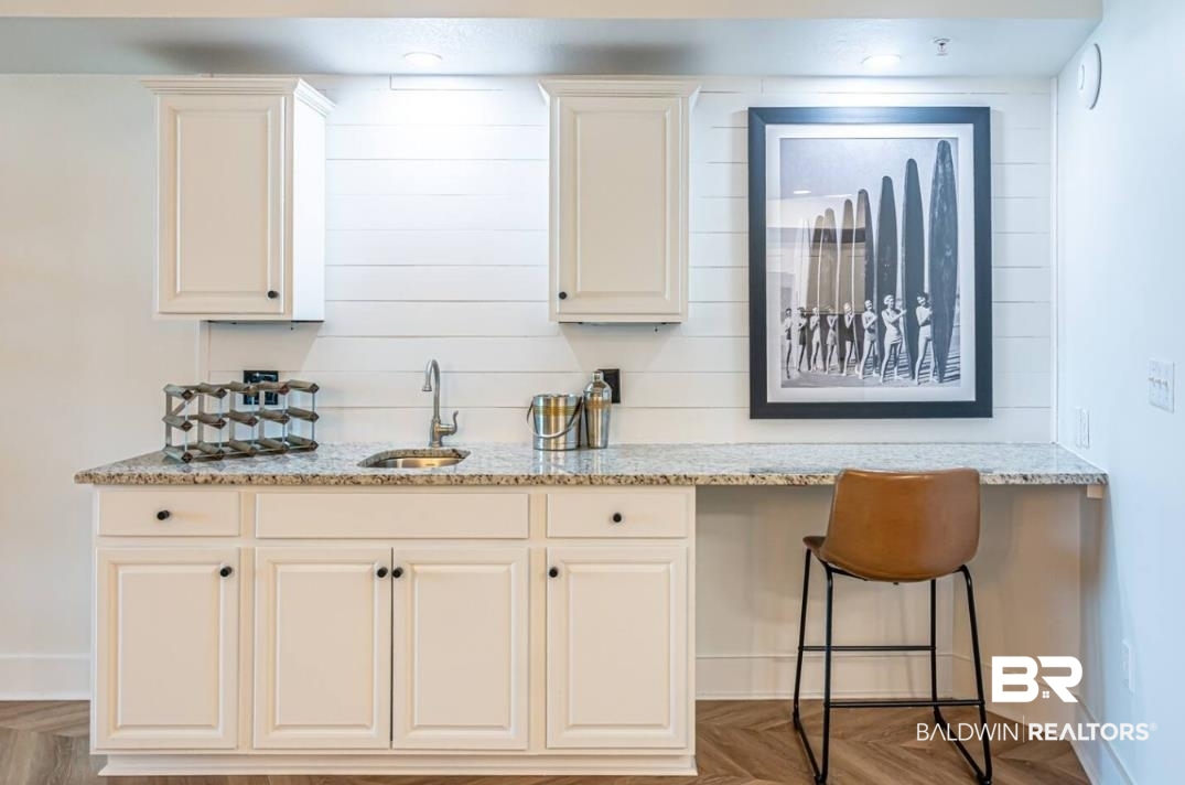 27800 Canal Road, Unit 212 Orange Beach, AL 36561 - Photo 12 of 43 Kitchen with baseboards, light stone countertops, a sink, and white cabinets