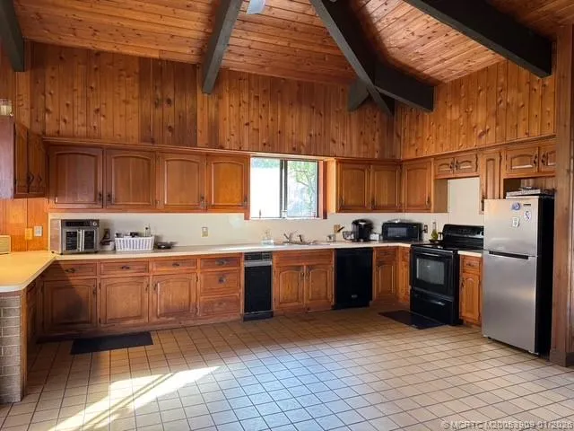 a large kitchen with stainless steel appliances granite countertop a stove a sink dishwasher and cabinets