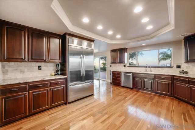a hallway with white cabinets and wooden floor