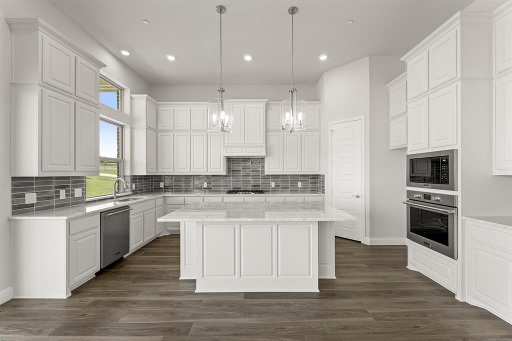 403 Spoonbill Road Sunnyvale, TX 75182 - Photo 12 of 34 a kitchen with kitchen island granite countertop a sink appliances cabinets and a counter top space