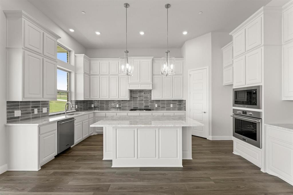 403 Spoonbill Road Sunnyvale, TX 75182 - Photo 14 of 34 a kitchen with kitchen island granite countertop a sink appliances cabinets and a counter top space