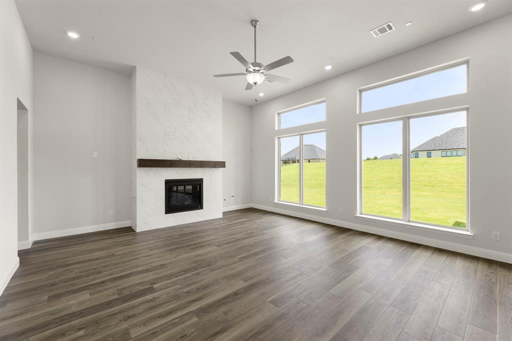 403 Spoonbill Road Sunnyvale, TX 75182 - Photo 7 of 34 an empty room with wooden floor a ceiling fan and windows
