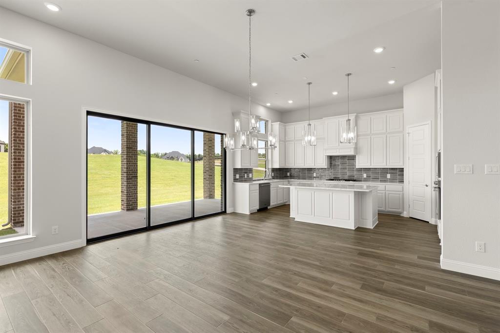 403 Spoonbill Road Sunnyvale, TX 75182 - Photo 10 of 34 a view of a kitchen with stainless steel appliances granite countertop a stove a sink and white cabinets with wooden floors