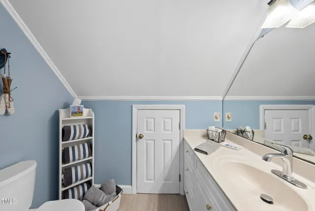 a view of a room with wooden floor table and windows