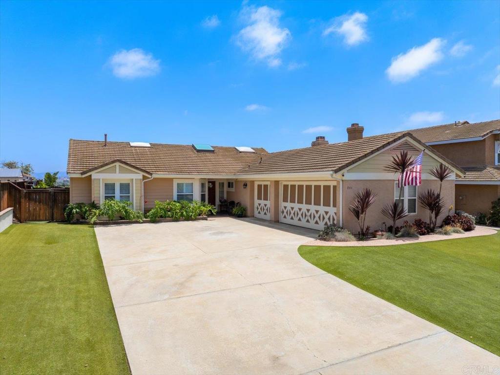 a front view of a house with a garden and yard