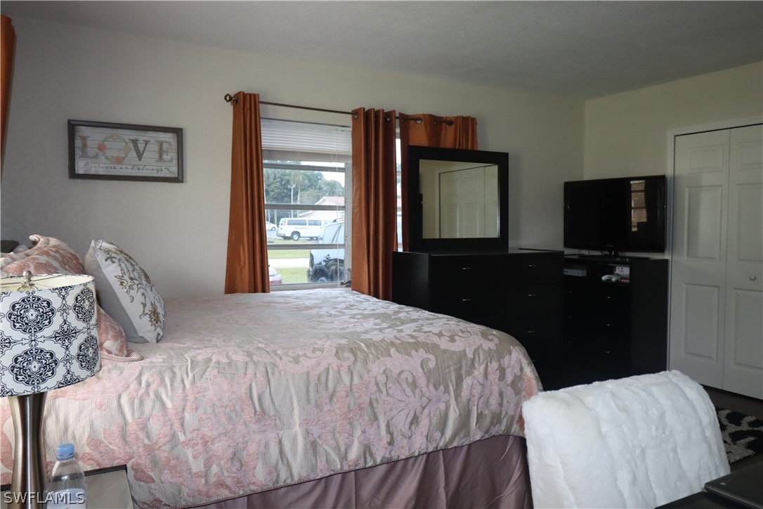 5529 Granada Road Fort Myers, FL 33919 - Photo 12 of 29 a bedroom with a bed and a flat tv screen on dresser