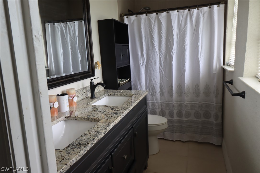 5529 Granada Road Fort Myers, FL 33919 - Photo 13 of 29 a bathroom with a granite countertop sink and a mirror