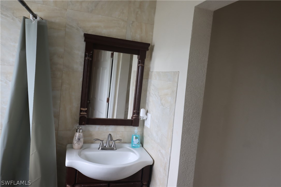 5529 Granada Road Fort Myers, FL 33919 - Photo 19 of 29 a bathroom with a sink and a mirror
