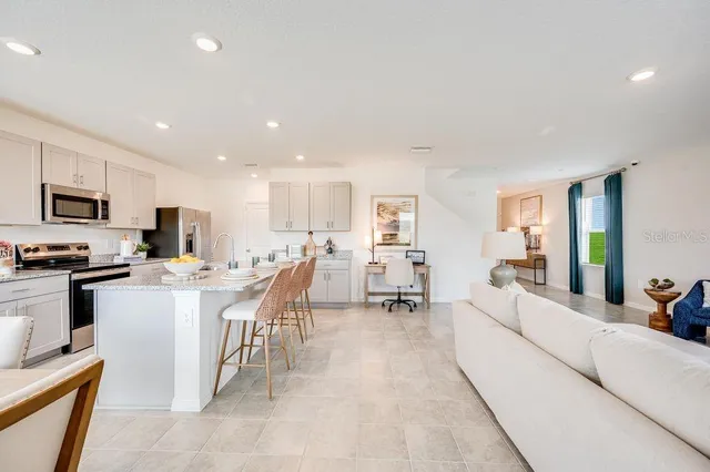 a large white kitchen with a large dining table and chairs