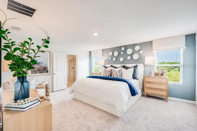 a bedroom with a bed and a potted plant