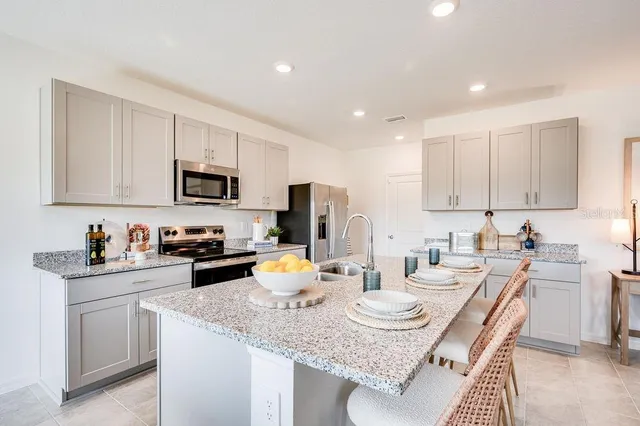 a kitchen with a sink a stove and white cabinets