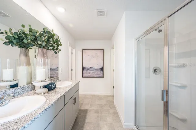 a bathroom with a granite countertop sink a mirror and a shower