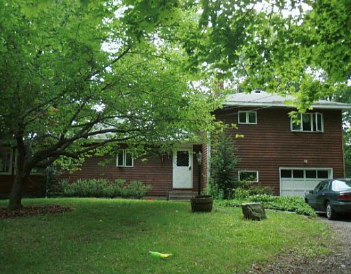 a front view of a house with a garden and yard
