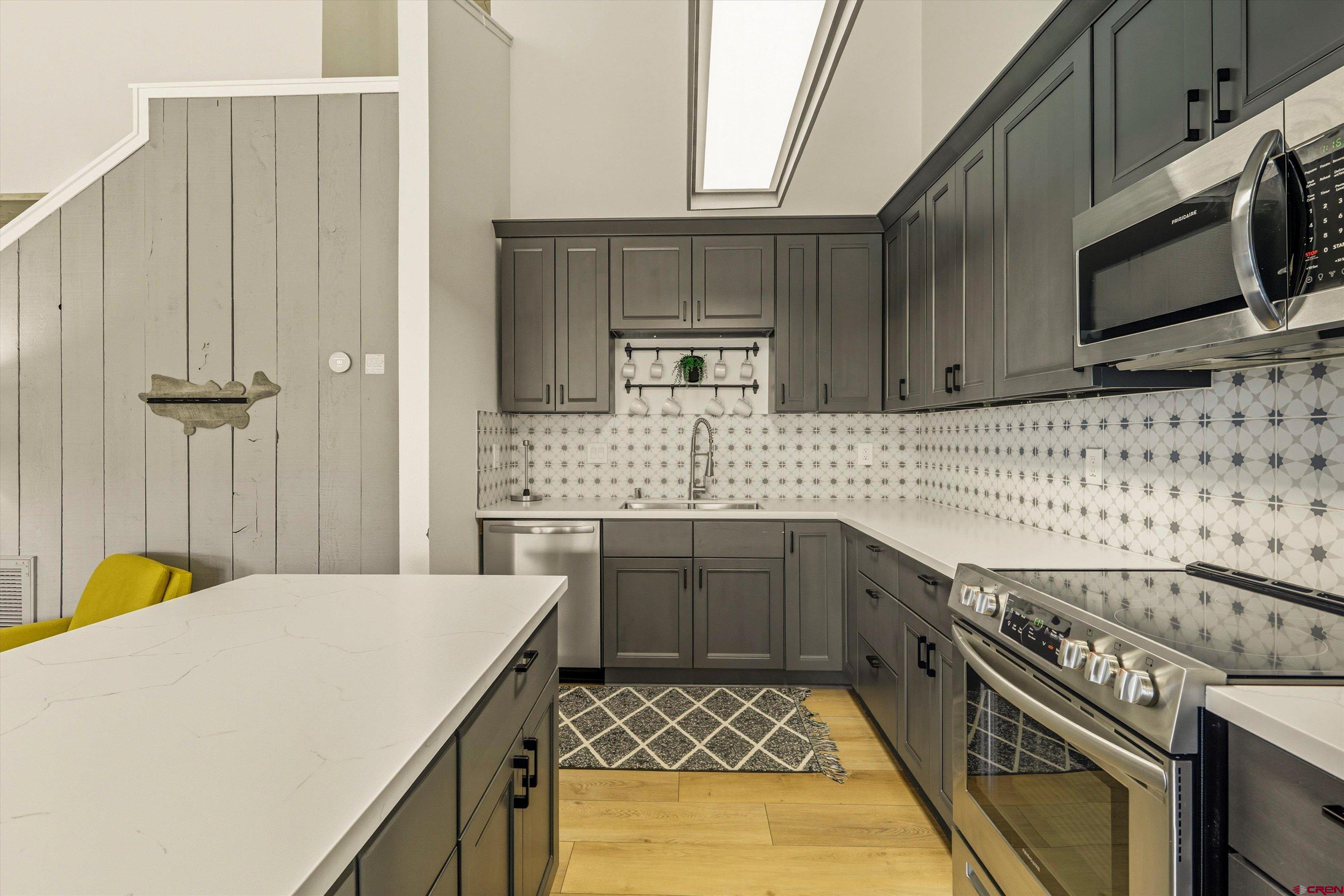 217 Pinon Causeway, Unit 3022 Pagosa Springs, CO 81147 - Photo 11 of 42 a kitchen with a stove a sink and a microwave
