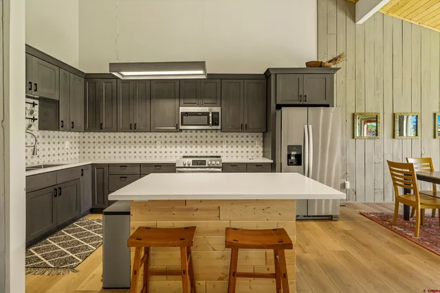 a kitchen with a table chairs and refrigerator