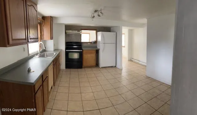 a kitchen with granite countertop a refrigerator and a stove top oven