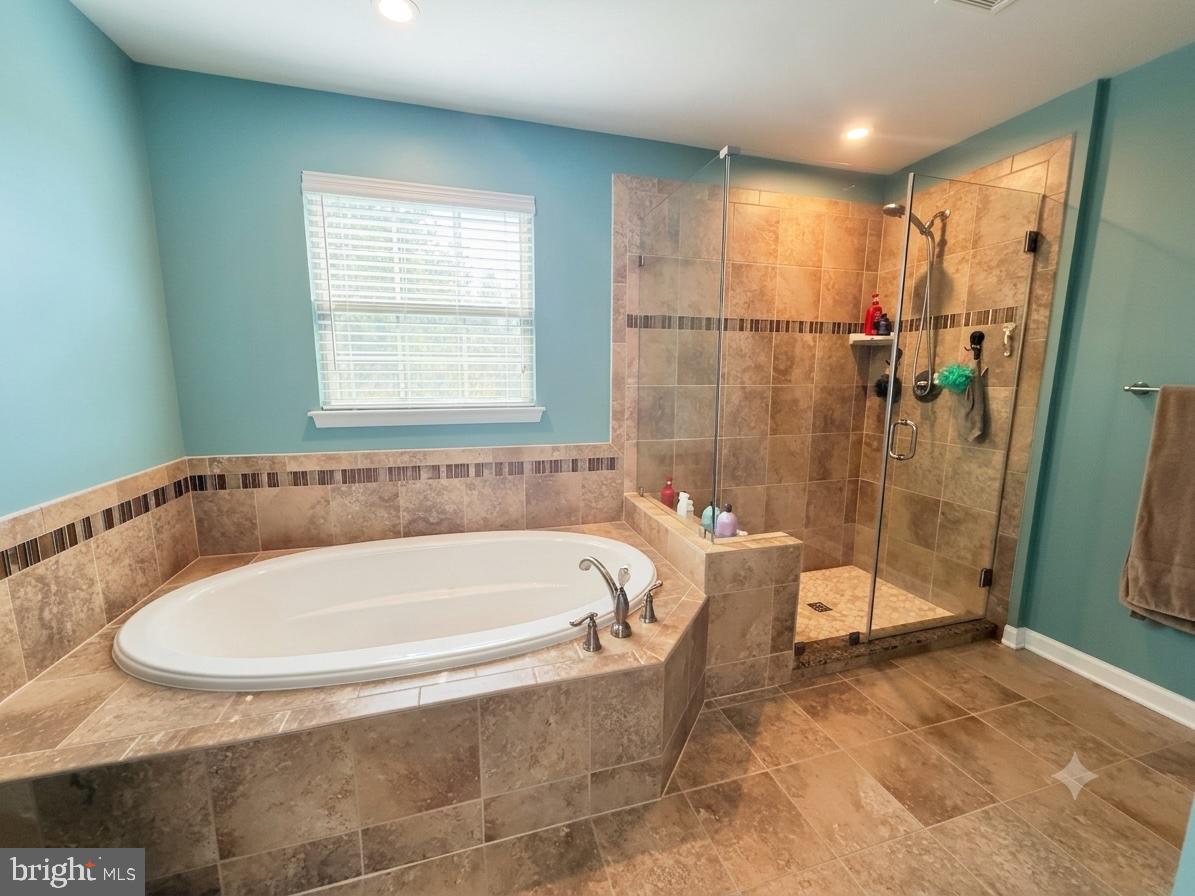 17875 Sugarberry Road Dumfries, VA 22026 - Photo 14 of 30 a bathroom with a tub and a shower