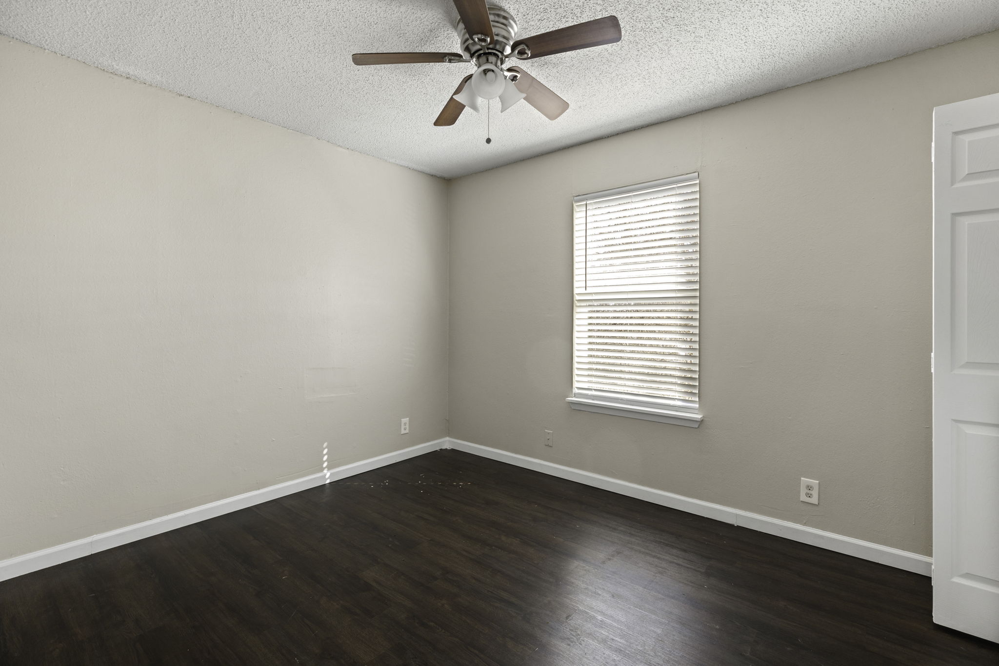 6110 Wheless Cove, Unit F Austin, TX 78723 - Photo 10 of 12 Unfurnished room with ceiling fan, dark wood finished floors, and a textured ceiling