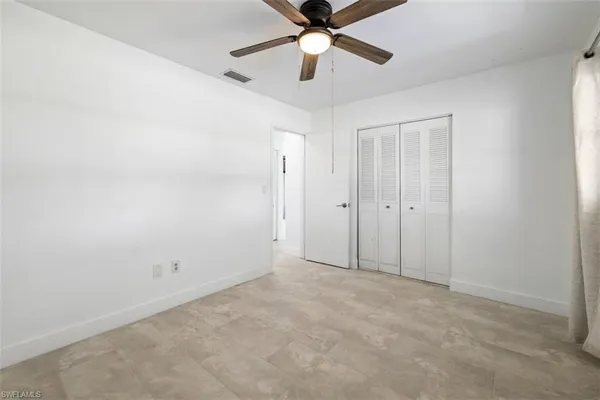 an empty room with chandelier fan