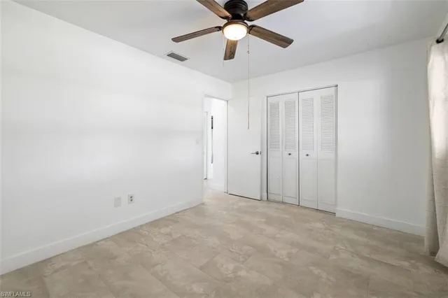 an empty room with chandelier fan