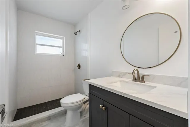 a bathroom with a toilet a sink and mirror