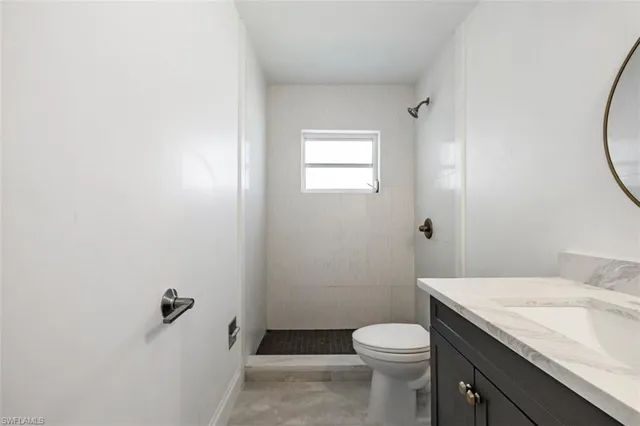 a bathroom with a granite countertop toilet and a sink