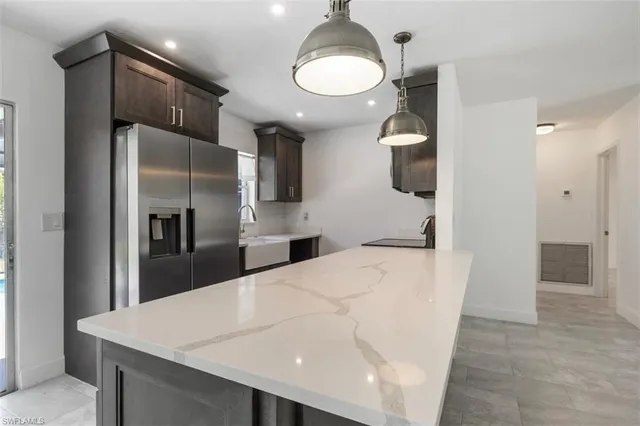 a kitchen with stainless steel appliances kitchen island a refrigerator and a sink