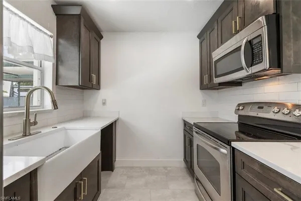 a kitchen with stainless steel appliances granite countertop a sink stove and microwave