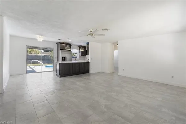 an empty room with kitchen and windows