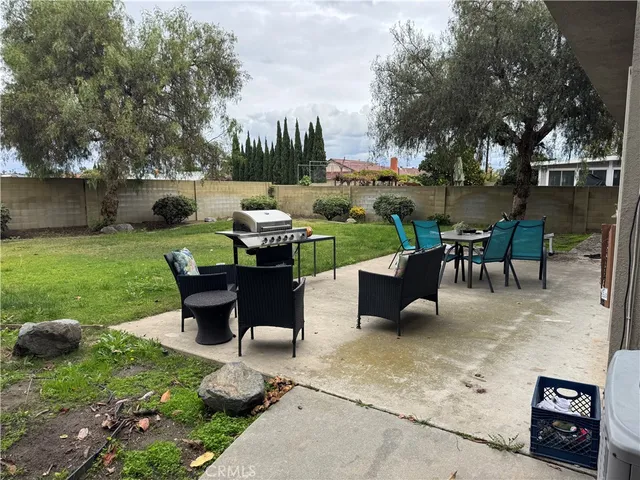 a view of a patio with table and chairs potted plants and a large tree