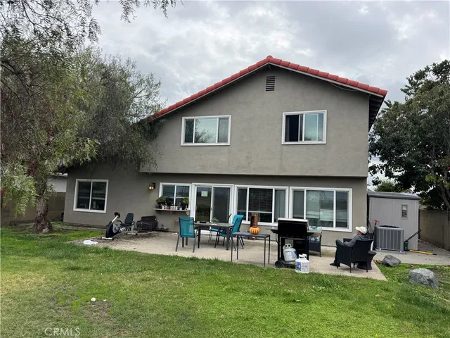 a patio with couches table and chairs with plants and trees