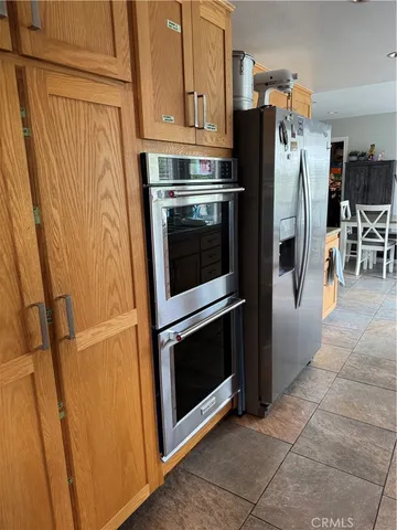 a kitchen with granite countertop a refrigerator and a stove top oven