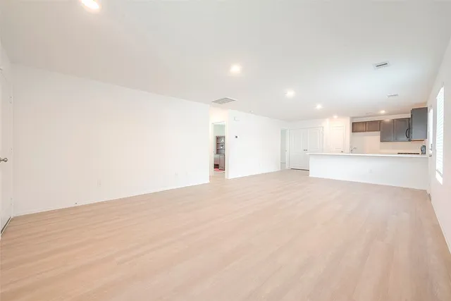 an empty room with wooden floor and window