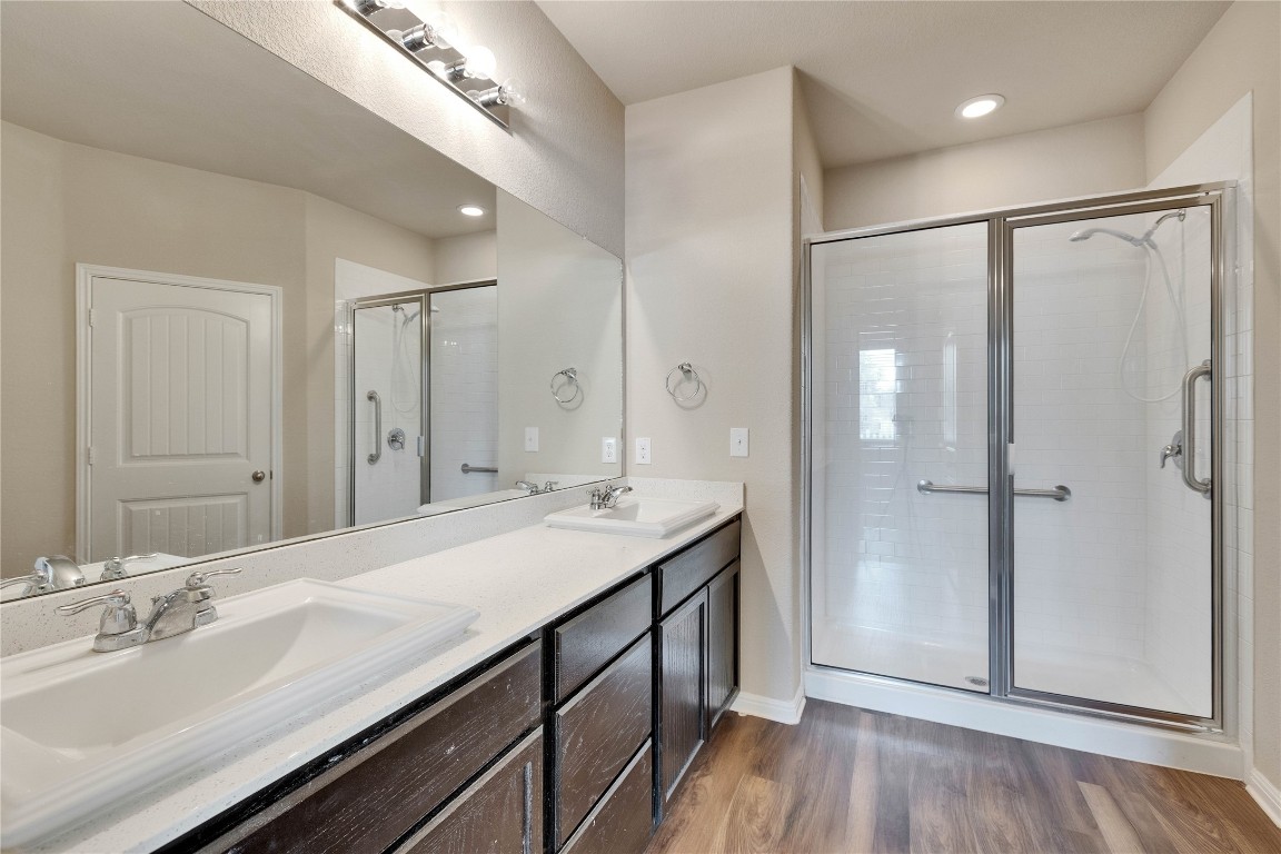 1701 Logan Drive, Unit 12 Round Rock, TX 78664 - Photo 15 of 26 a bathroom with a double vanity sink a mirror and shower