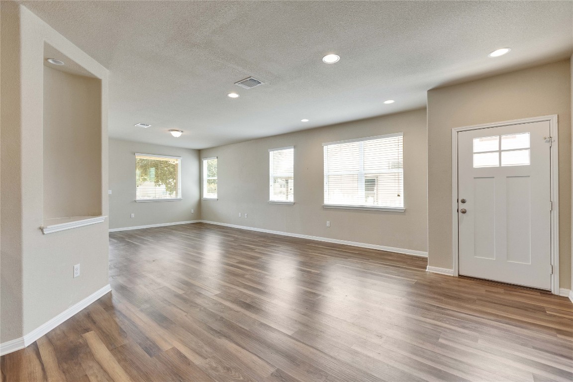 1701 Logan Drive, Unit 12 Round Rock, TX 78664 - Photo 9 of 26 an empty room with wooden floor and windows