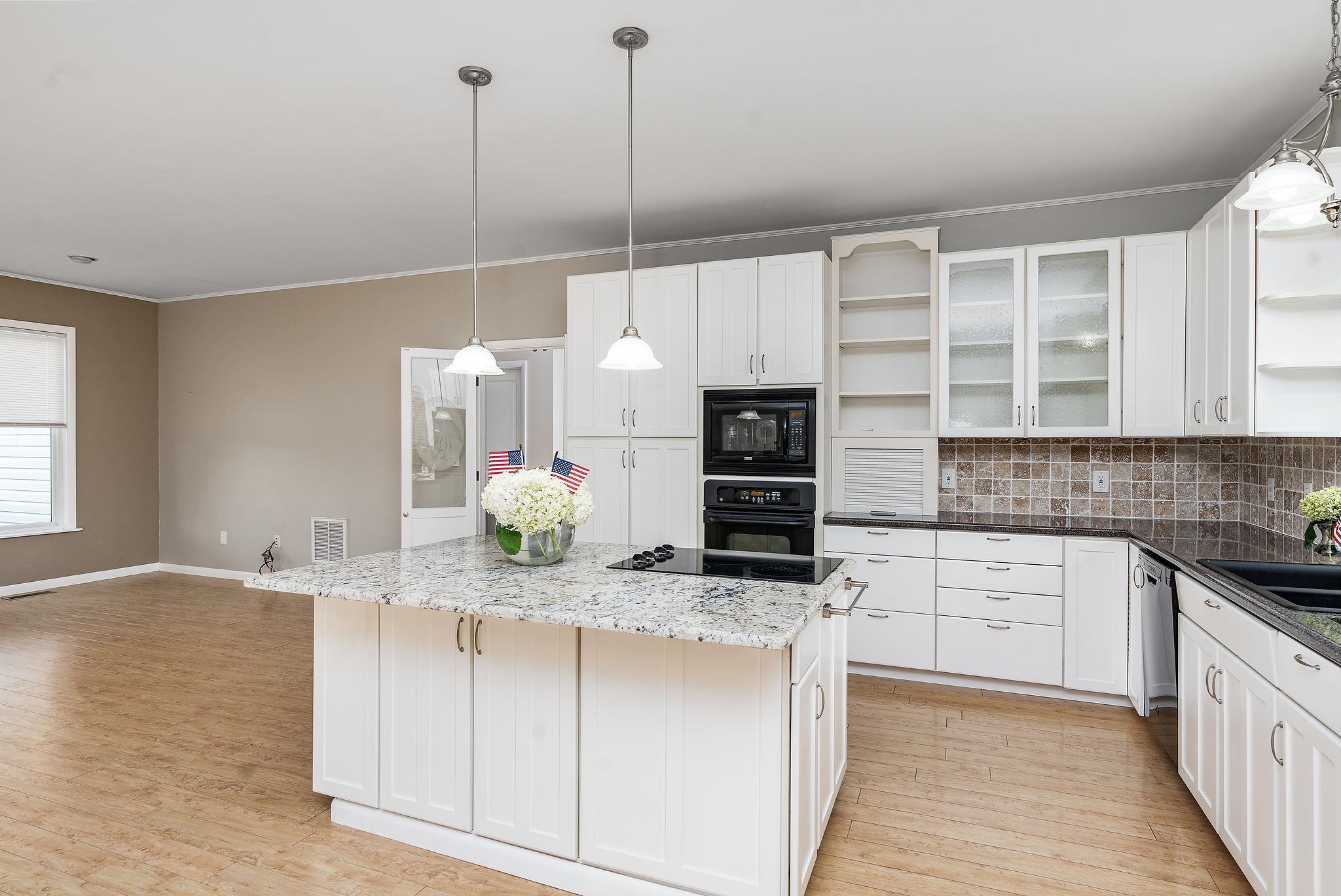 1373 Rockfish Road Waynesboro, VA 22980 - Photo 15 of 75 a kitchen with stainless steel appliances kitchen island granite countertop a stove a sink and white cabinets with wooden floor