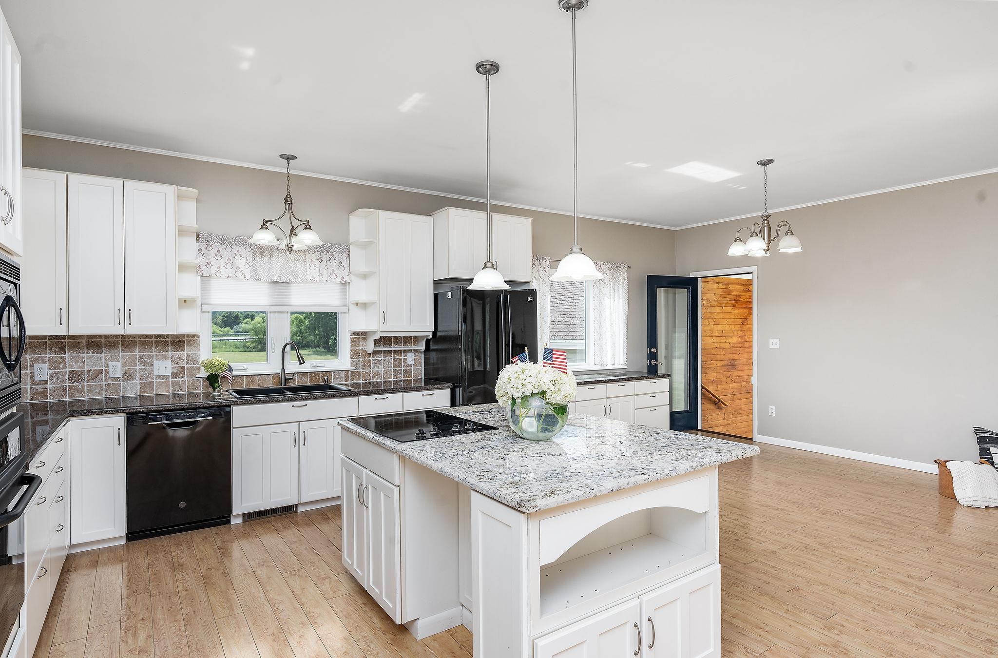 1373 Rockfish Road Waynesboro, VA 22980 - Photo 22 of 75 a kitchen with kitchen island granite countertop a stove a sink a center island and wooden floor