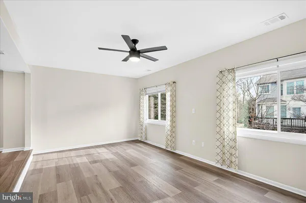 a view of a big room with wooden floor and windows