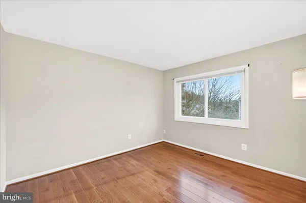 an empty room with wooden floor and window