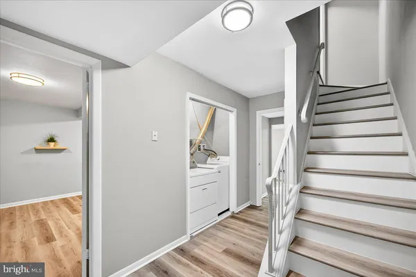 a view of a hallway with wooden floor and entryway