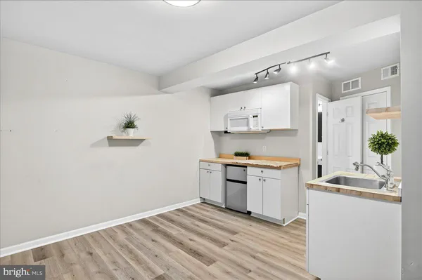 a kitchen with granite countertop a sink cabinets and stainless steel appliances