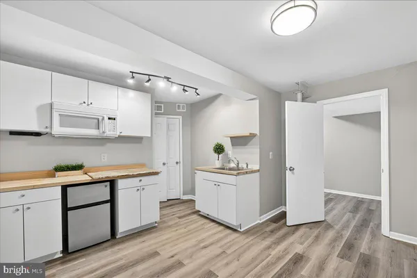 a kitchen with white cabinets and sink