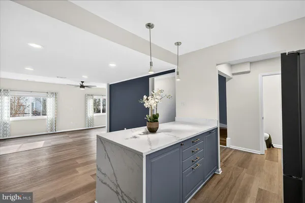 a kitchen with kitchen island white cabinets appliances and wooden floor