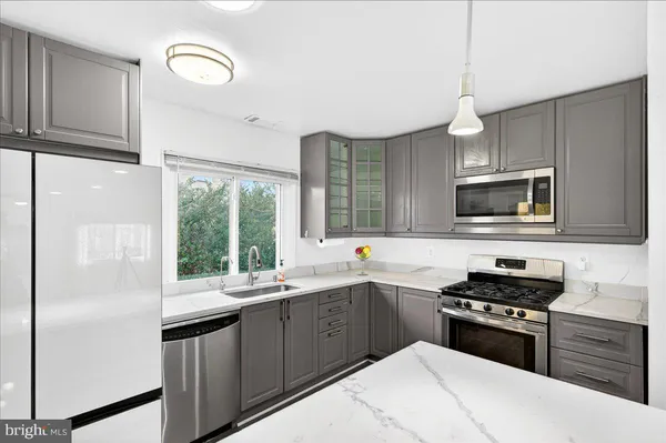 a kitchen with a sink a stove and cabinets