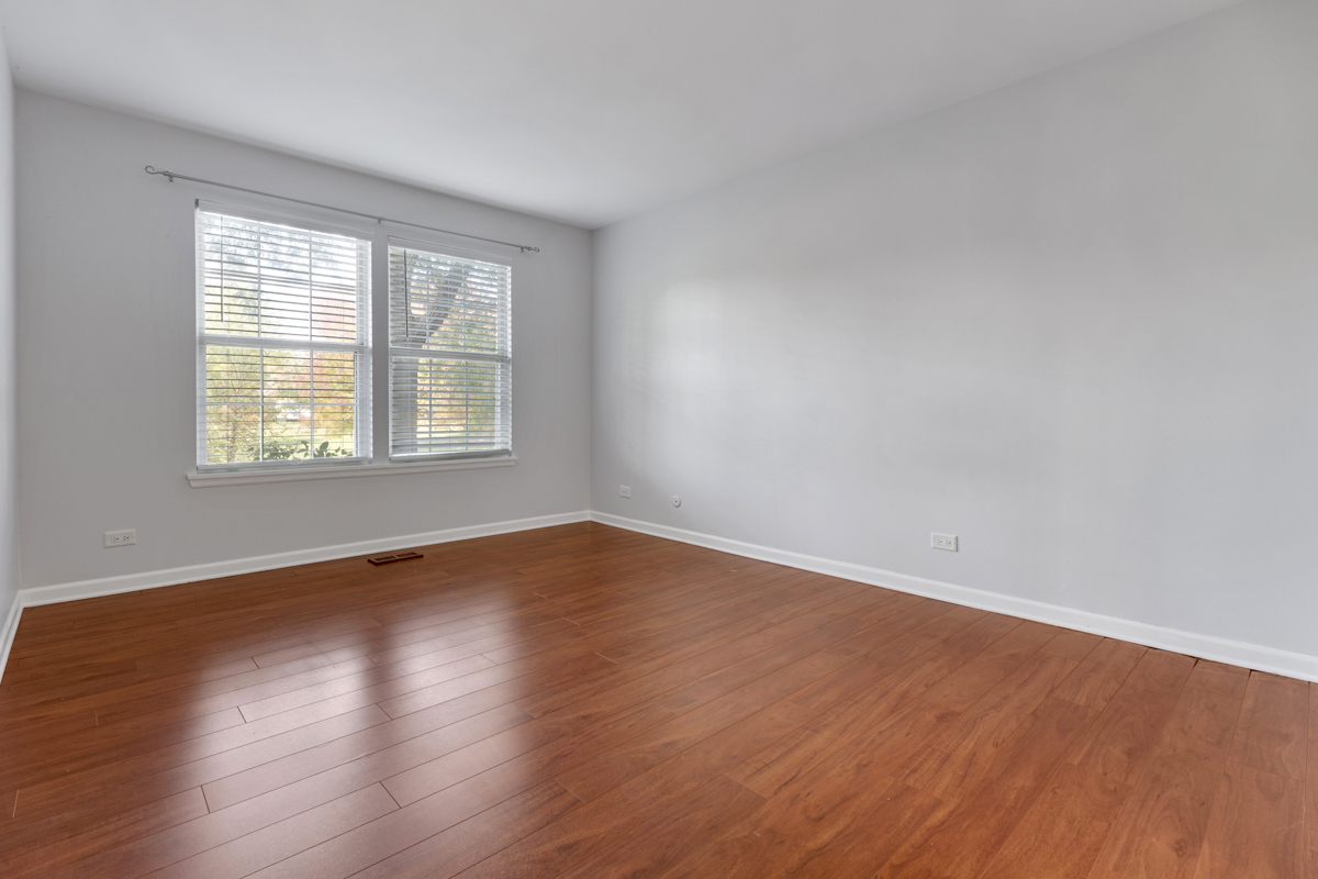 148 White Branch Court Buffalo Grove, IL 60089 - Photo 11 of 25 a view of an empty room with wooden floor and a window