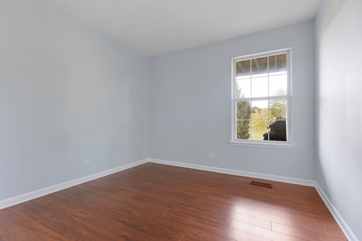 148 White Branch Court Buffalo Grove, IL 60089 - Photo 14 of 25 a view of an empty room with wooden floor and a window