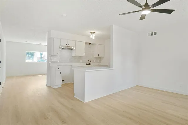 a view of a kitchen with wooden floor and windows