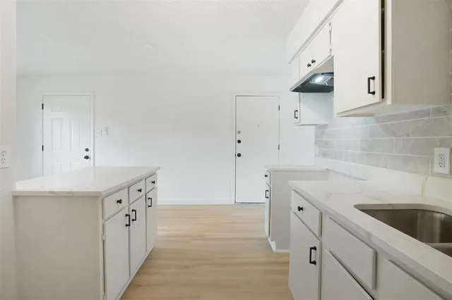 a kitchen with granite countertop a sink and cabinets