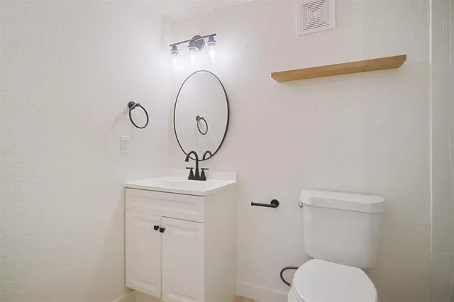 a bathroom with a toilet a sink and mirror