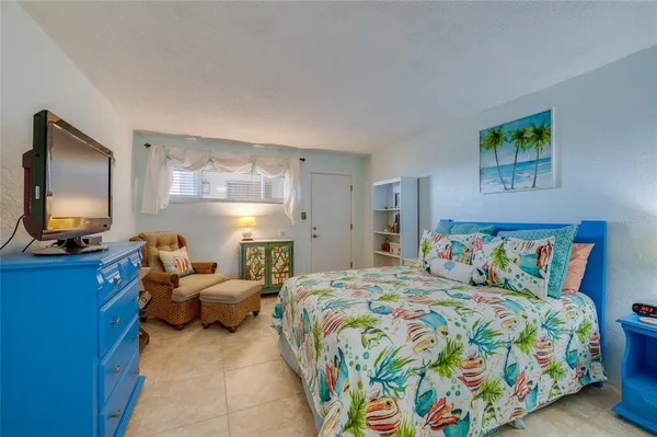 a bedroom with a bed and a flat screen tv